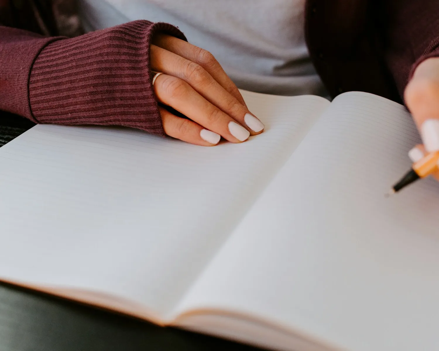 Een hand schrijft in een leeg schrift